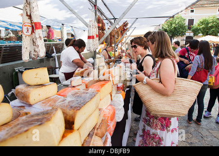 Di commercianti che vendono Palma prosciutto e formaggio in città Vecchia Pollensa mercato di Domenica in la principale piazza di Plaza Mayor e. Foto Stock