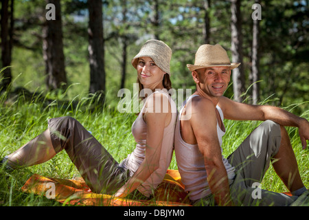 Croazia, Paklenica, coppia giovane rilassa la schiena a schiena in erba Foto Stock