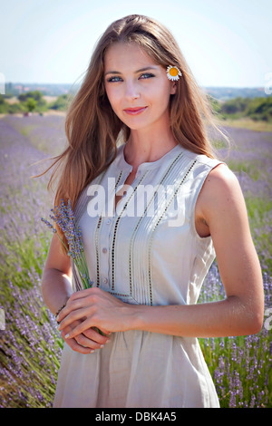 Giovani donne con fiore nei capelli in piedi nel campo di lavanda, Croazia, Dalmazia, Europa Foto Stock