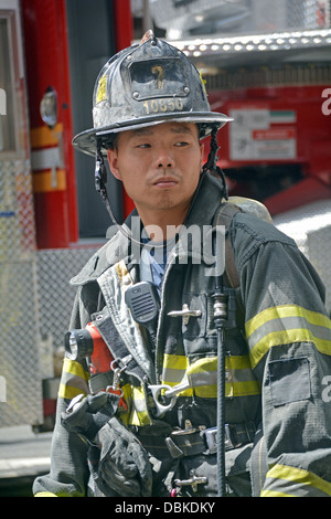 Un americano asiatico vigile del fuoco su un lavoro su Broadway nella sezione di Soho di Lower Manhattan, New York City. Foto Stock