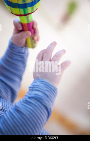 Baby boy giocando con il sonaglio, Monaco di Baviera, Germania Foto Stock