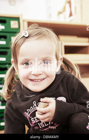 Bambina tenendo un blocco di costruzione, Kottgeisering, Baviera, Germania, Europa Foto Stock
