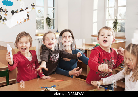 I bambini nella scuola materna di gettare la carta aerei in volo, Kottgeisering, Baviera, Germania, Europa Foto Stock