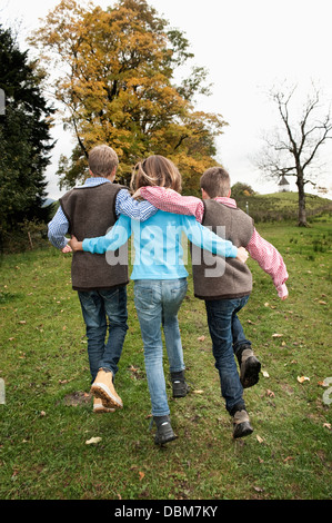 Tre bambini camminare insieme nel campo, Baviera, Germania, Europa Foto Stock