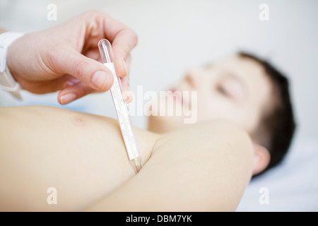 Medico donna tenendo la temperatura del ragazzo, osijek, Croazia Foto Stock