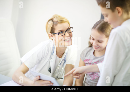 Medico donna spiega la diagnosi per i bambini, utilizzando una tavoletta digitale, osijek, Croazia Foto Stock