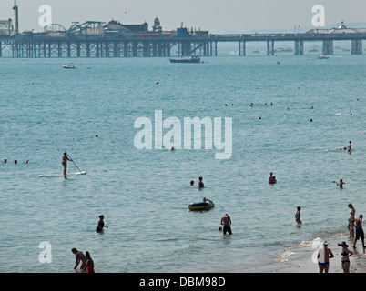 Le persone che si godono il mare e la spiaggia di Brighton in una calda giornata estiva Foto Stock