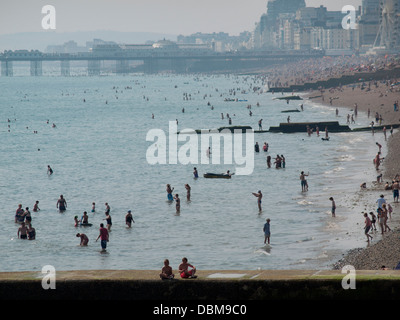 Le persone che si godono il mare e la spiaggia di Brighton in una calda giornata estiva Foto Stock