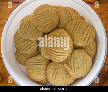 In casa burro di arachidi biscotti, pane appena sfornato, in un bianco contenitore in plastica, un tavolo di legno. Stati Uniti d'America. Foto Stock