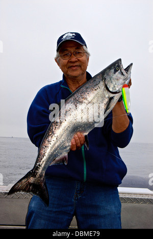 Sorridenti Asian pescatore azienda sport catturato il Salmone Chinook trolling spoon lure Banca Swiftsure BC Foto Stock