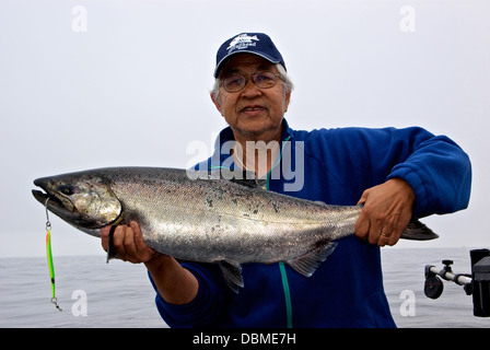 Sorridenti Asian pescatore azienda sport catturato il Salmone Chinook trolling spoon lure Banca Swiftsure BC Foto Stock