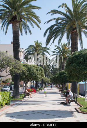La gente seduta e camminare lungo la passeggiata nella città costiera di Ceriale, nord Italia, Europa Foto Stock