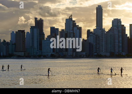 Stand-Up-Paddle-Surfing sotto la luce della sera nella baia di Balneario Camboriu Foto Stock