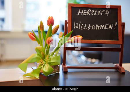 Lavagna con i tedeschi 'Herzlich Willkommen' slogan di benvenuto Foto Stock