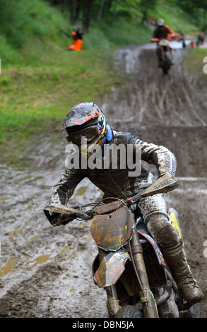 Terreni fangosi in pista per una gara di supermotard sullo sporco parte della pista. focalizzato sul primo piano con un pilota. Foto Stock