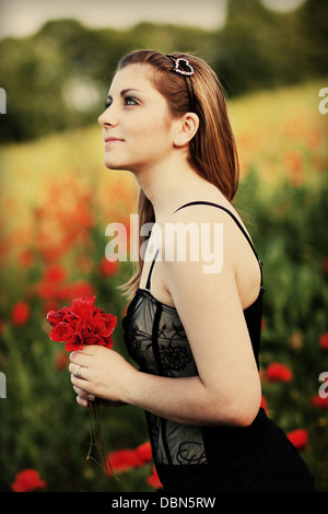 Giovane donna in un campo di papavero, Croazia, Europa Foto Stock