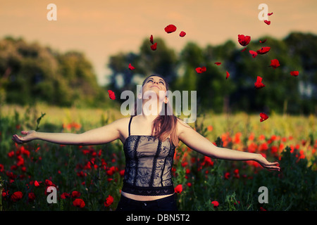 Giovane donna giocando con papaveri in un campo di papavero, Croazia, Europa Foto Stock