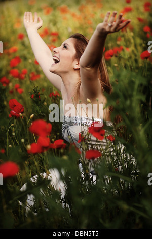 Giovane donna in un campo di papavero, braccia, Croazia, Europa Foto Stock