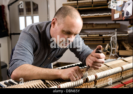 Costruttore di strumenti di regolazione di un pianoforte, Regensburg, Baviera, Germania Foto Stock