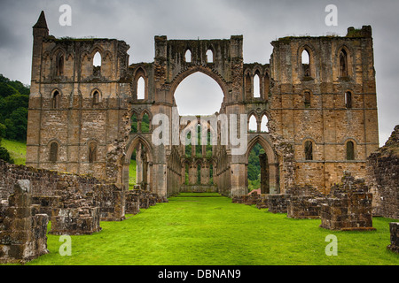 Vista panoramica delle rovine di Rievaulx Abbey sotto cloudscape, North Yorkshire Moors, Parco Nazionale, Inghilterra Foto Stock