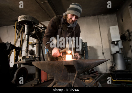 Fabbro di metallo di martellamento su di una incudine, Landshut, Baviera, Germania Foto Stock