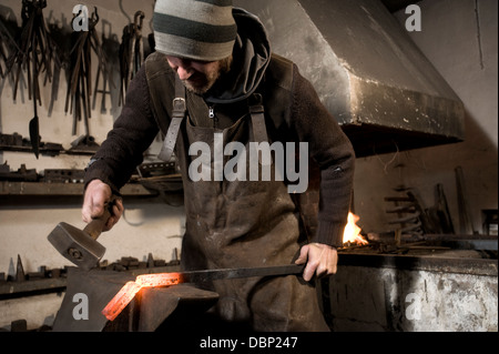 Fabbro di metallo di martellamento su di una incudine, Landshut, Baviera, Germania Foto Stock