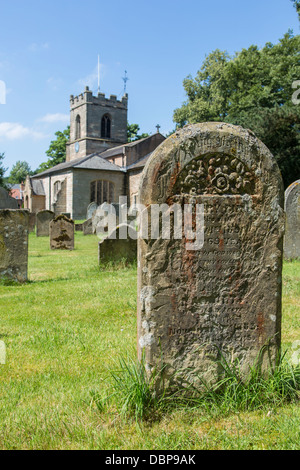 Weathered e coperte di lichene, headstone, Chiesa di San Pietro e di San Paolo, Exton village, Nottinghamshire Foto Stock