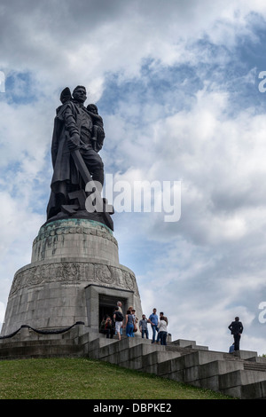 Monumento ai caduti sovietici, Treptower Park, Berlino. Statua del soldato sovietico che tiene il bambino e la spada e calpestando la svastika rotta. Monumento russo Foto Stock