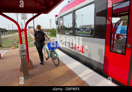 Di " commuters " femmina esce da una stazione della metropolitana-linea ferroviaria con la sua bicicletta ad un trasporto pubblico stop di Austin in Texas Foto Stock