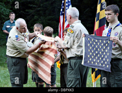 I dirigenti senior di Boy Scout Troop 755 preparare un vestito di stracci bandiera americana per una pensione adeguata durante una cerimonia a giugno 14, 2013 in Gambrills, MD. È tradizione cerimoniale per tagliare la sezione blu, quindi ciascuna striscia e infine posizionare il pezzo di bandiera in un incendio come vi saluto. Foto Stock