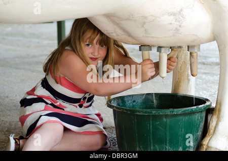 Bambina di mungere una vacca artificiale presso l'Arca di Noè zoo fattoria, Bristol, Inghilterra, Regno Unito Foto Stock