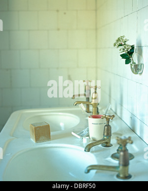 Sapone quadrato su bianco doppi lavandini con chrome tocca in bianco piastrellate townhouse bagno Foto Stock