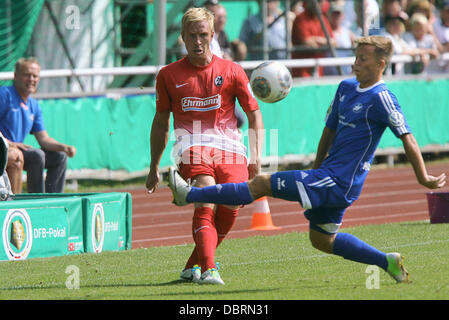 Londra, Regno Unito. 03 Ago, 2013. Neustrelitz Tony Fuchs (R) il sistema VIES per la palla con Friburgo Mike Hanke (L) durante il primo round DFB Cup match tra TSG Neustrelitz e SC Freiburg a Parkstadion a Neustrelitz, Germania, 03 agosto 2013. Foto: Jens BUETTNER (NOTA: La DFB vieta l'utilizzazione e la pubblicazione di immagini sequenziali su internet e altri media online durante il match (comprese a metà tempo). Periodo di bloccaggio! La DFB permette l'ulteriore utilizzazione e la pubblicazione delle immagini per i servizi mobili (soprattutto MMS) e per il DVB-H e DMB solo dopo la fine del Foto Stock