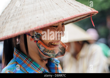 HANOI, Vietnam - Una donna che indossa un tradizionale cappello conico vietnamita in un mercato alimentare di Hanoi, Vietnam. Foto Stock