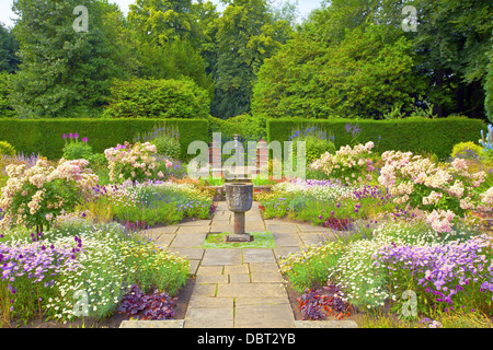 Contrassegnato inglese giardino estivo con vaso di pietra ornamento. Foto Stock