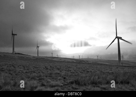 Le turbine eoliche stagliano contro un oscuro inizio del cielo della sera. In bianco e nero. Foto Stock