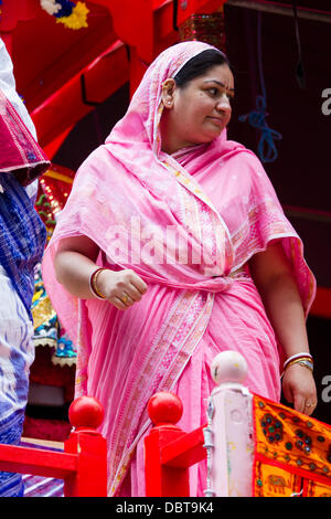 Leicester, Regno Unito, 4 agosto 2013. Un Hare Krishna seguace sulla cima di un carro durante il Rathayatra street festival di Leicester dal centro città. Tre 40ft carri sono stati tirati a mano attraverso la città, accompagnati da danza e musica. Rathayatra è un 5,000 anni di festival originari di Jagannatha puri in India. Credito: Graham Wilson/Alamy Live News Foto Stock