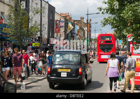 Vista generale della trafficata Camden High Street, vicino a Camden Market, con un taxi nero e un iconico, tradizionale bus rosso a due piani. Londra, Inghilterra, Regno Unito. Foto Stock