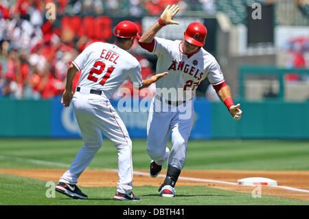 Anaheim, California, USA. 4 Ago, 2013. Agosto 4, 2013 Anaheim, California: Los Angeles Angeli terza base coach Dino Ebel (21) dà 5 a Los Angeles Angeli center fielder Mike Trote (27) dopo aver colpito un home run nel primo inning durante il Major League Baseball gioco tra il Toronto Blue Jays e il Los Angeles Angeli a Angel Stadium il 4 agosto 2013 ad Anaheim, in California. Rob Carmell/CSM/Alamy Live News Foto Stock