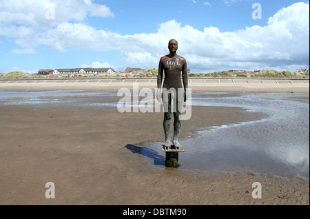 Amore scritto su uno di Antony Gormley statue chiamato un altro posto a Crosby beach. Foto Stock