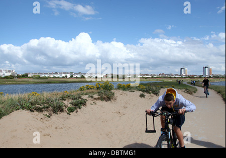 Ragazzi con la bicicletta pedalando attraverso Crosby Parco costiero in Merseyside Foto Stock