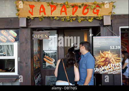 Asian giovane guardando il menù a Japadog stile giapponese hotdog ristorante su Robson Street, Vancouver, BC, Canada Foto Stock