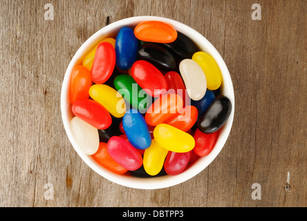 Jelly Beans in una ciotola su sfondo di legno Foto Stock