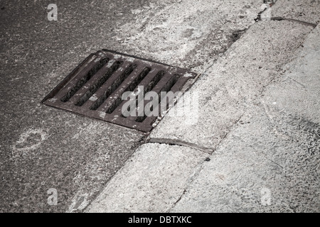 Coperchio di drenaggio sul lato strada Foto Stock