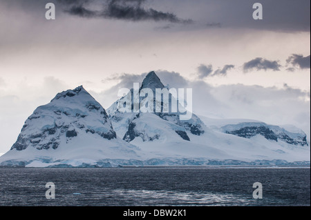 Nuvole scure su montagne e ghiacciai di Port Lockroy stazione di ricerca, l'Antartide, regioni polari Foto Stock