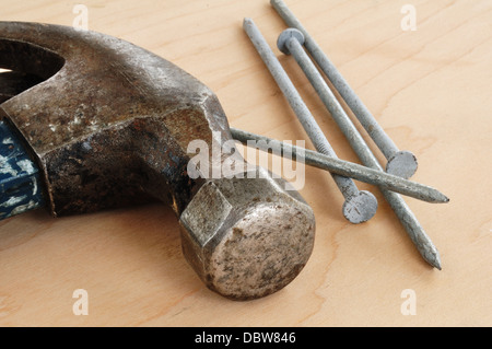 Martello da carpentiere e chiodi su una tavola di legno Foto Stock