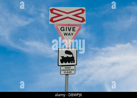 Treno livello incrocio con cartelli di avvertimento Foto Stock