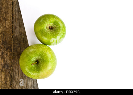 Mele Verdi e white paper su legno vecchio tavolo, obsoleti texture di legno. Foto Stock