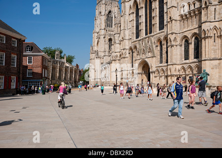 Persone turisti visitatori a piedi in piazza e percorso ciclabile Al transetto Sud di York Minster in estate York North Yorkshire Inghilterra Regno Unito Foto Stock