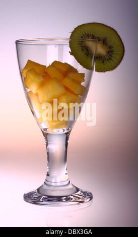 Vetro con ananas tagliata a cubetti e kiwi Foto Stock